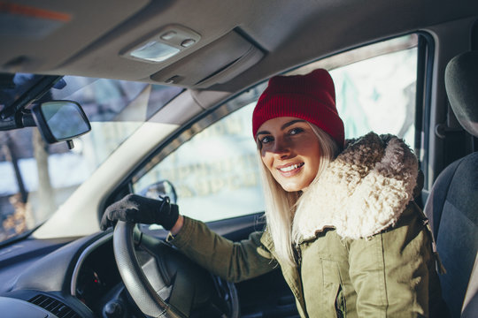 Portrait of happy woman in warm clothing driving car