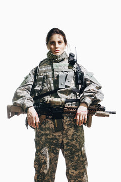 Portrait of female soldier standing with rifle against white background