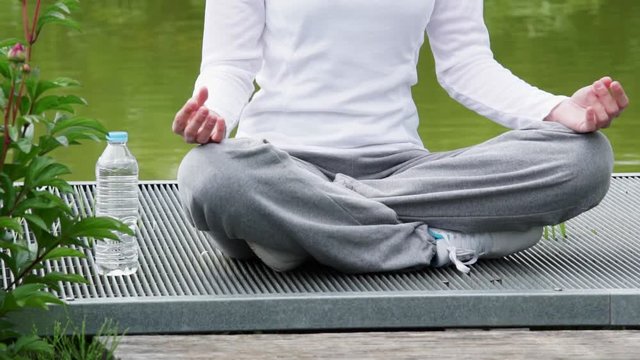 View of a Young attractive woman practising yoga in a park
