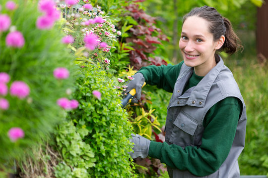 Young attractive woman working in a public garden