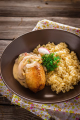 Fried meat with couscous garnish in bowl.