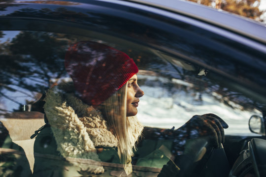 Woman in warm clothing driving car