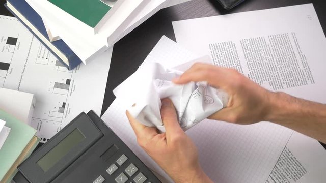 Nervous and frustrated student makes a paper ball from his homework.