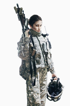 Army soldier carrying rifle and helmet standing against white background