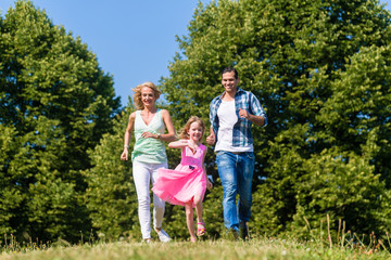 Familie spielt Fangen im Sommer auf Weise