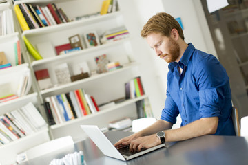 Obraz na płótnie Canvas Young redhair man working on computer
