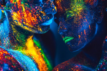 People are colored fluorescent powder. a pair of lovers dancing