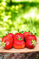 Group of fresh, organic strawberry on wooden board, outdoors