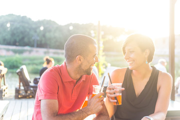 Couple having a cocktail outdoor at sunset