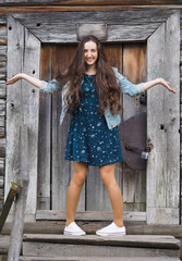 Beautiful young woman playing with her hair in front of old wood