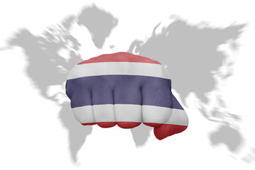 fist with the national flag of thailand on a world map background