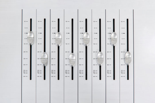 music mixer slider buttons on metallic casing forming an alternate pattern with small amplitude