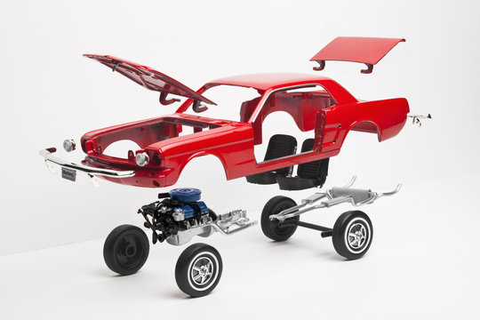A model car taking a part, some pieces in mid-air