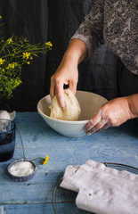 Female preparing and knead the dough in bowl. Rustic french styling.