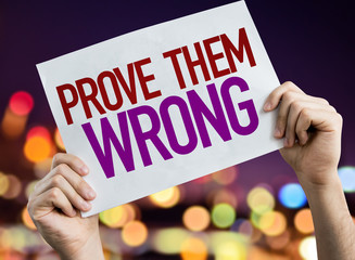 Prove Them Wrong placard with night lights on background