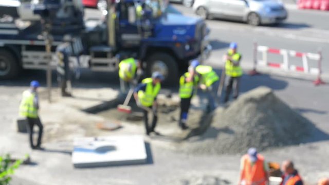 Road workers repair the road, blurred defocused background