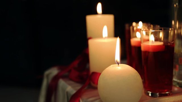 Peaceful valentine candles light for dinner on table decorated with tablecloth and red tapes at night