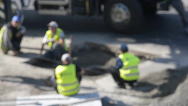 Road workers repair the road, blurred defocused background