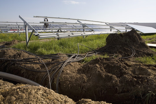 Installation of pipes and solar panels in a field