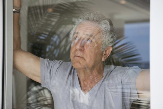 A senior man looking out a window