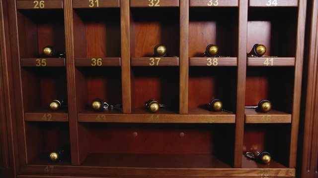Rack with the keys to the hotel rooms. Hand takes key