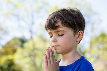 Fototapeta premium Boy praying with eyes closed