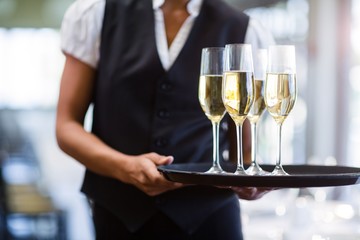 Waitress holding serving tray with champagne flutes 