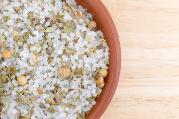 Close top view of simple Moroccan blend of spices in a bowl atop a wood table.
