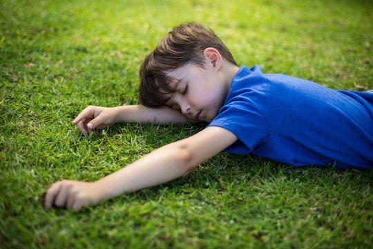 Young boy sleeping in park