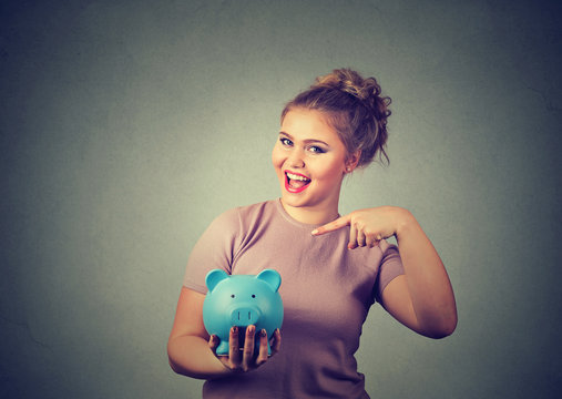 Happy woman holding piggybank