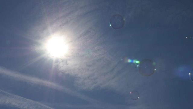 Soap bubbles flowing against blue sky and sun 1080p FullHD slow-mo footage - Slow motion soap bubbles in the air 1920X1080 HD video