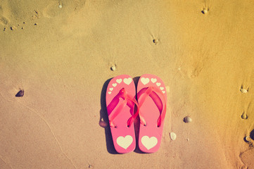 Top view of flip flops left on sandy beach background