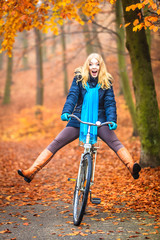 Fototapeta na wymiar Happy active woman riding bike in autumn park.