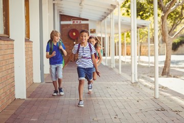 Happy school kids running in corridor