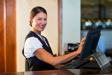 Portrait of waitress using a computer at counter