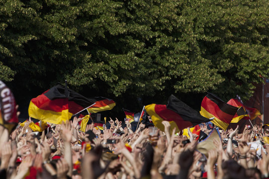 Detail of people in a crowd waving German flags