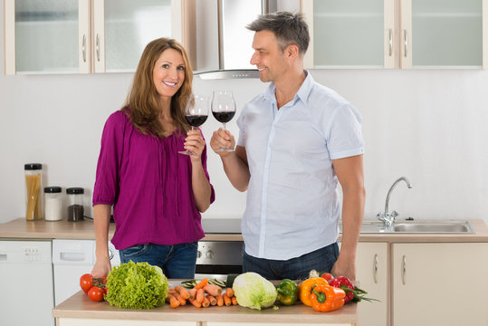 Portrait Of Happy Couple Toasting Red Wine