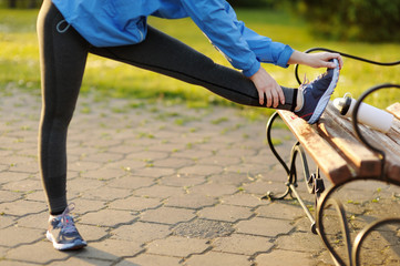 Exercise woman stretching hamstring leg muscles duing outdoor ru