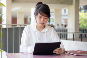 Portrait of thai student university beautiful girl using her tablet