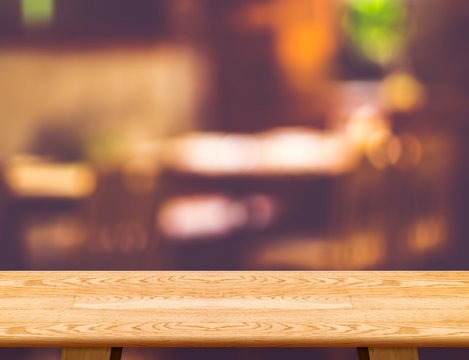 Empty wooden table and blurred cafe bokeh light background. Mock
