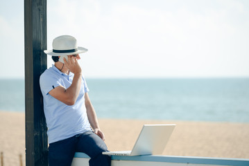 Business man enjoying working outside with laptop, talking on phone