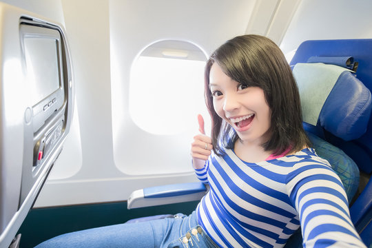 Happy woman sitting in airplane