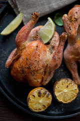 Whole baked crispy chickens with lemon and lime, high angle view