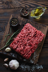 Raw fresh beef mincemeat in a rustic wooden setting, top view