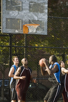 Four men playing basketball