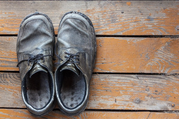 the old genuine leather shoes on a wooden background