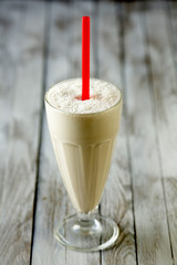 Glass of fruit smoothie isolated on wooden background