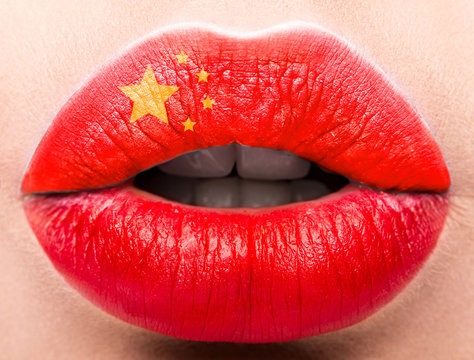 Female lips close up with a picture flag of China. Red color, yellow stars