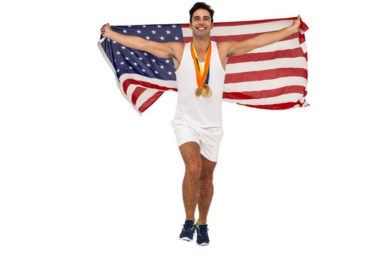 Athlete posing with gold medals and american flag after victory