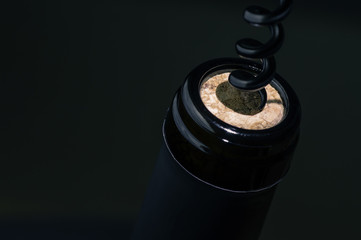 Black corkscrew opens wine